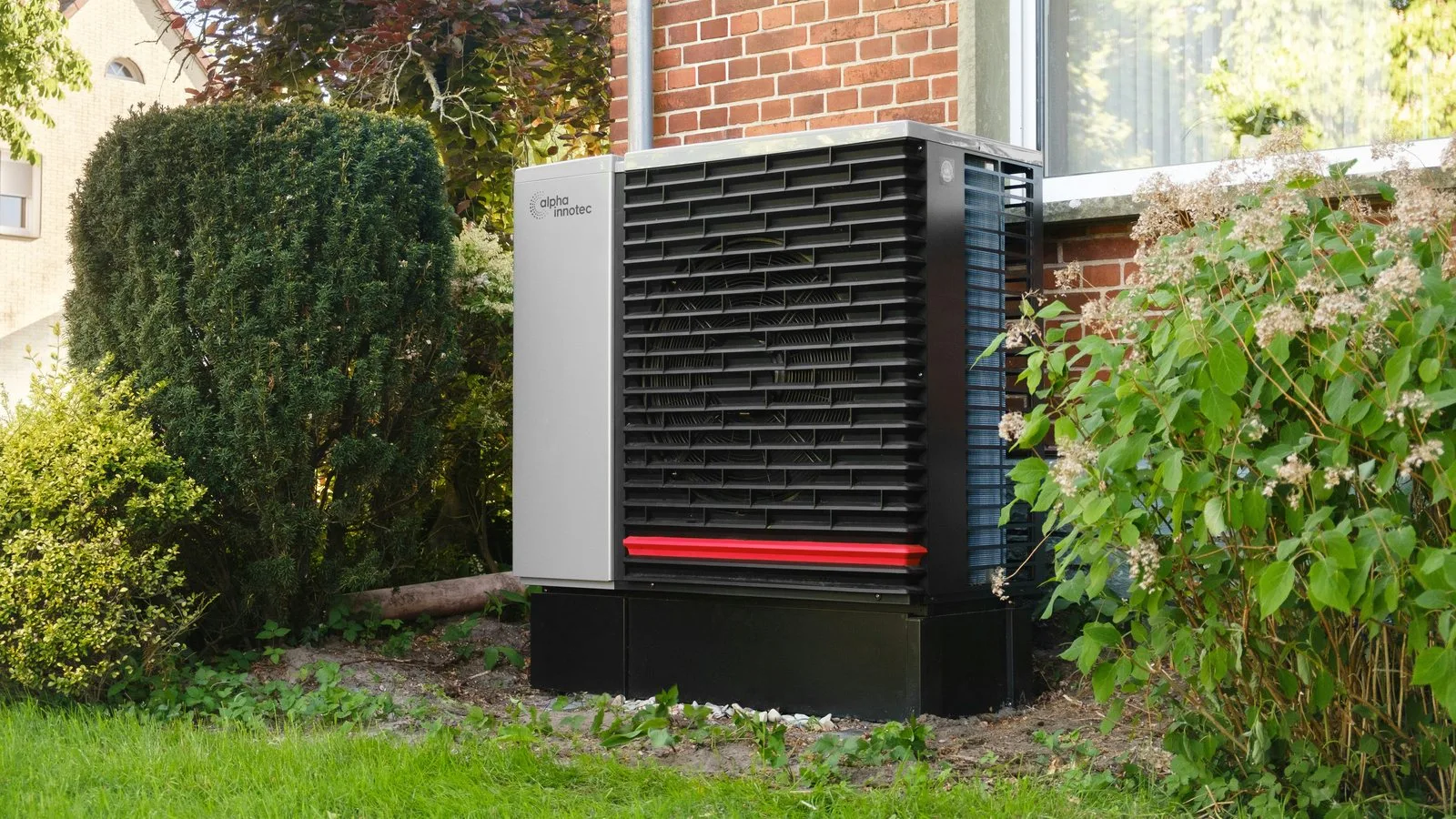 Buitenunit van een warmtepomp tegen een gevel